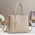 Borsa a mano minimalista in pelle beige con pendente fiore di perla e tracolla lunga - Albicocca