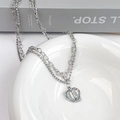 Detailed macro view of heart pendant with lightning crack pattern on layered silver necklace - Split Heart Layered Necklace