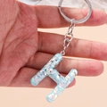 Close-up of letter H keychain with light blue pearlescent texture and silver ring - Letter H