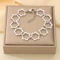 Elegante pulsera de acero inoxidable plateado con eslabones de pétalos florales huecos - Estilo Flor Hueca Plateada (KB210100-Z)