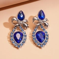 Macro shot of vintage style earrings with blue teardrop stones and silver bow knots - Blue & Silver (925 Silver Needle)