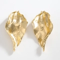 Detailed view of golden leaf earrings with irregular hammered metallic texture and shine - Gold