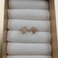Pink natural stone stud earrings with golden four-claw setting in a jewelry box - Strawberry Quartz