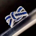 Eleganter silberner Schleifenring mit tiefblauen Steinen und funkelnden Akzenten - US 6 / Blau