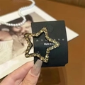 Detail of star-shaped hair clip with champagne crystals on a brand card - Champagne