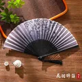 Chinese folding fan with purple floral butterfly print and black tassels on wood - 11 Clusters of Flowers