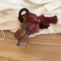 Dettaglio della molletta per capelli in tweed a quadri bordeaux su fondo in maglia bianca - Molletta a Fiocco Plaid (Caffè-Rosso)