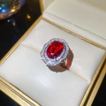 Dettaglio di un anello in argento con un grande zircone rubino rosso ovale e diamanti halo - Argento Rosso Ovale