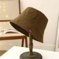 Brauner Anglerhut aus strukturiertem Stoff mit Metallemblem auf einem Holzständer - M (56-58cm) / Camel