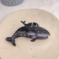 Macro shot of whale hair claw clip with marble texture and rhinestone on a ceramic plate - Black Double Whale