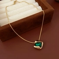 Dettaglio di una collana vintage dorata con smeraldo su una lussuosa scatola di velluto - Collana Con Pendente Quadrato Verde Smeraldo