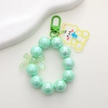 Macro view of green pearlescent beaded keychain with bow and transparent bear charm - K1772 Mermaid Green Beaded Bear