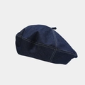 Detailed view of dark blue denim beret with white contrast stitching and top button detail - One Size / Dark Blue