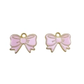 Close-up of two pink enamel bow charms with golden metal edges for DIY jewelry making - Pink
