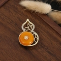 Detail of a golden gourd brooch with hollow carvings and orange gemstone inlay - Orange Stone Gourd