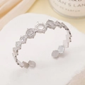 Elegant silver stainless steel open bangle featuring circular and sunburst engraved patterns - Sun Pattern / Steel