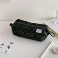 Close-up of quilted black pencil case with oversized zipper and stylish white woven label - Black