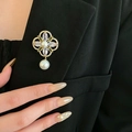 Détail d'une broche fleur en perles et pierres précieuses sur le revers d'un tailleur noir - Fleur de Gemme Vintage Dorée (62#)