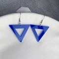 Detailaufnahme blauer Acryl-Dreieck-Ohrringe mit silbernen Metallhaken auf Stoff - Blaues Dreieck