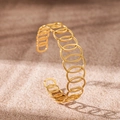 Detailed macro view of 18K gold plated stainless steel hollow C-shaped open bangle - Round