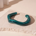 Detail of green wavy acrylic bangle with marble texture on minimalist stone base - Dark Green Texture