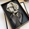 Elegant silk scarf featuring black and white chain and diamond pattern folded in tray - White