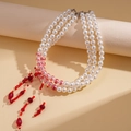 Detailed macro view of triple-layer faux pearl necklace with red crystal tassels - 3-Layer Tassel Style / Necklace-Red
