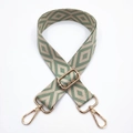 Close-up of sage green and beige embroidered diamond pattern wide bag strap with gold hooks - Beige Base Bean Green