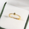 Macro detail of 18k gold plated letter E ring with small diamonds in a green jewelry box - E Gold