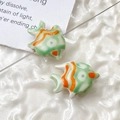 Macro shot of two handmade goldfish ceramic beads in green and orange for DIY jewelry - Price per Piece / Green Orange and White Stripes