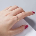 Elegante gouden ring met een ronde robijn en kleine diamanten op een hand met roze nagels - Gouden Wijnrood Edelsteen