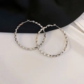 Macro view of large silver geometric multifaceted hoop earrings on a minimalist background - Silver Hoop (38#)
