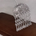 Dettaglio del fermacapelli vintage in argento con motivo a uccello traforato e nappe - Nappa Argento