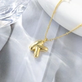 Vista macro di una collana con ciondolo a lettera K in oro 18K dal design a palloncino - un solo ciondolo, senza catena / Lettera K