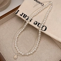 Close-up of a double-layered French style pearl and silver chain necklace on linen - Freshwater Pearl Pendant Silver Necklace