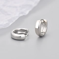 Close-up of polished silver huggie earrings on a minimalist grey background - Polished Smooth Style / Medium / White Gold