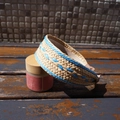 Detail of beige woven straw headband with blue stitching on a rustic wooden surface - Blue and Beige Patchwork Wide Edge