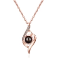 Rose gold projection necklace with crystal inlay and curved pendant on white background - Abstract Curve Rose Gold