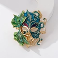 Exquisite gold mask brooch with blue and purple enamel and green leaf details - Cyan