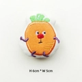 Detail view of cartoon vegetable plush brooch with embroidery measuring 6cm by 5cm - Carrot