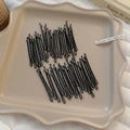 Makro-Detail schwarzer gewellter Metall-Haarnadeln auf einem creme-farbenen Tablett - Schwarz (50 Stück)