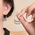 Close-up of silver hoop earrings with beaded edge detail worn by a model in warm light - Retro Beaded Edge Hoop / Silver