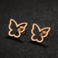 Macro shot of rose gold stainless steel butterfly stud earrings on a dark textured surface - 670 Hollow Butterfly / Rose Gold