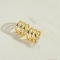 Dettaglio del ear cuff dorato a tre fasce lucide su superficie bianca testurizzata - Placcato Oro 14k Ear Cuff a 3 Strati