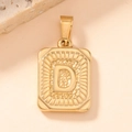 Detailed macro view of a gold square pendant featuring an engraved letter D design - Letter D