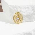 Macro detail of golden sunburst pendant with zircon and shell inlay on a white stone - Sun Flame Style (ZYN-DMK653G)
