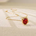 Close-up of gold plated necklace with large oval red gemstone pendant on stone background - Red Oval Style (BD022-red)