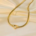 Dettaglio di una chiusura a cuore dorata su catena a serpente su seta color beige - Collana Cuore Dorato (O508)