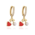 Close-up of gold cherry earrings with red heart charms and white pearls on white background - Gold Heart Pearl Cherry Earrings