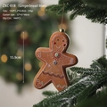 Gingerbread man Christmas ornament with white icing detail hanging on snowy pine branch - Gingerbread Girl